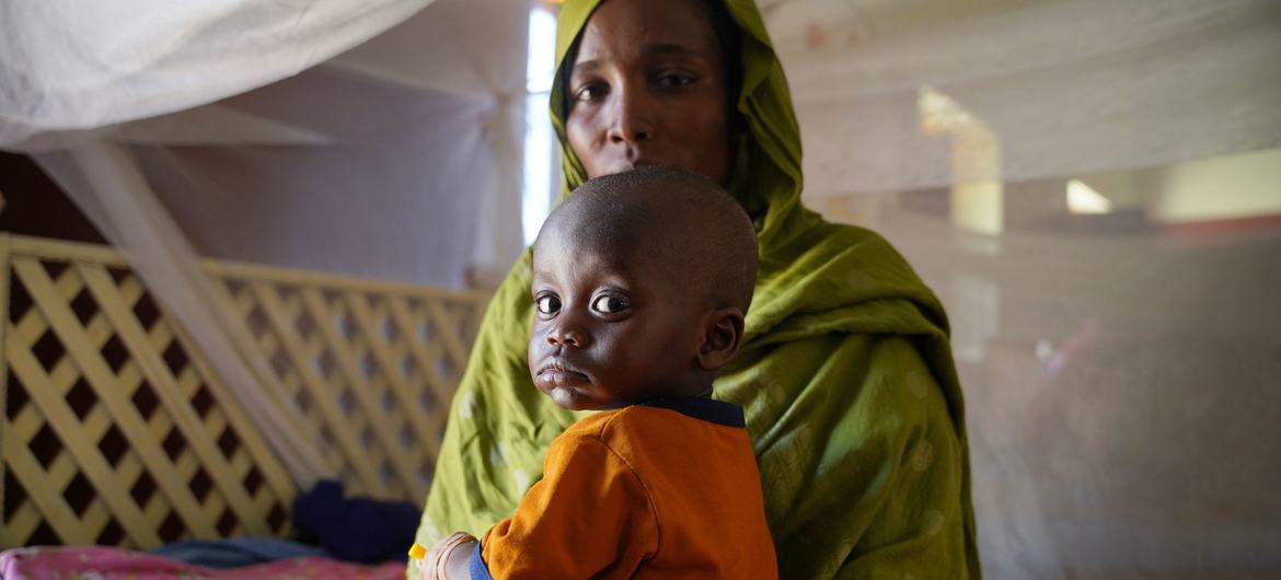 Uma mãe leva seu filho doente a um centro de saúde apoiado pelo Unicef no norte de Darfur, durante o conflito no Sudão.