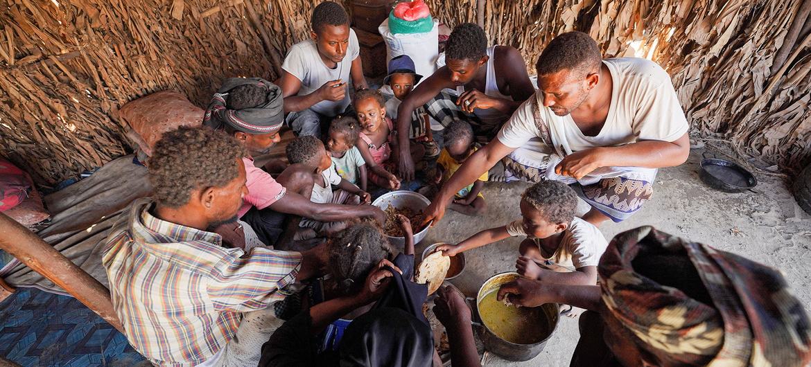 Uma família compartilha uma refeição no Iêmen com alimentos fornecidos pelo programa mensal de assistência alimentar do PMA