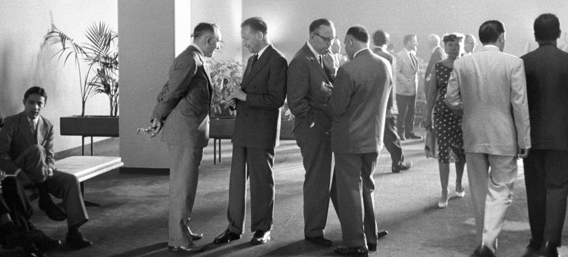 O então secretário-geral da ONU, Dag Hammarskjöld (em pé, o segundo da esquerda), em conversa no Salão dos Delegados na Sede da ONU após uma Sessão Especial de Emergência em 1958.