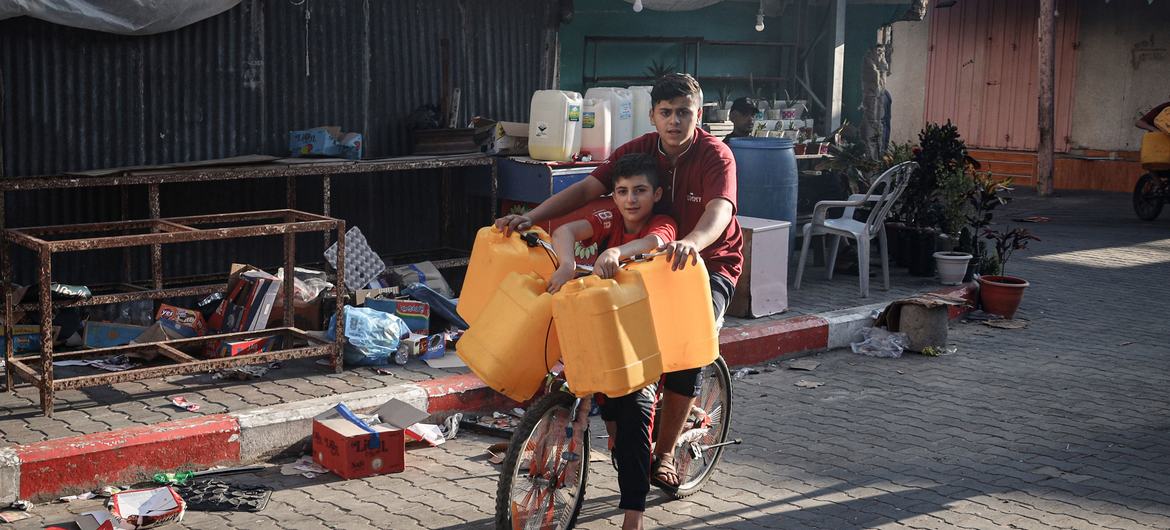 Crianças coletam água na cidade de Rafah, no sul da Faixa de Gaza.