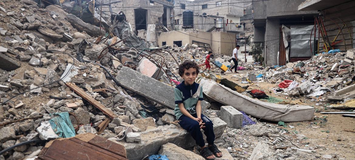 Um menino de 8 anos da Cidade de Rafah, senta-se entre os escombros da casa destruída de sua família.