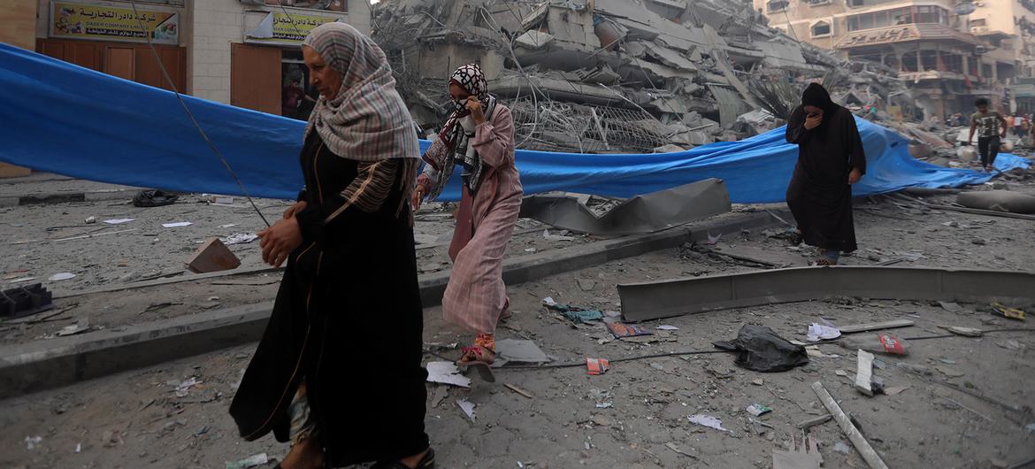 Mulheres palestinas caminham pelos escombros do bairro Nasr, na Cidade de Gaza