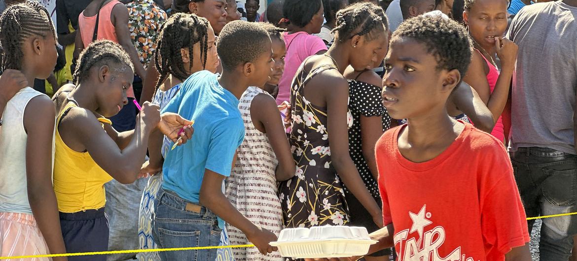 Crianças no Haiti fazem fila para receber uma refeição quente e água distribuída pelo PMA em Porto Príncipe