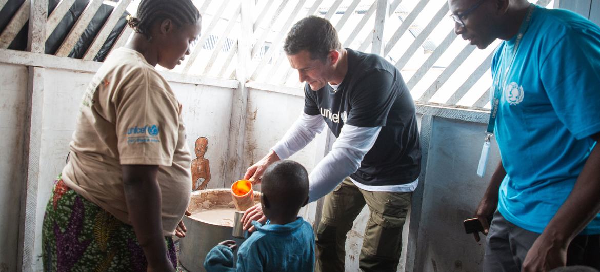 Orlando Bloom serve mingau em um centro de nutrição apoiado pelo Unicef no local de Bushagara para pessoas deslocadas internamente no leste da RD Congo