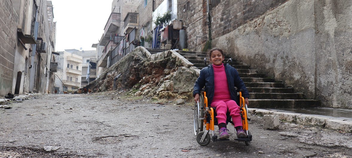 Hanaa, de oito anos, que ficou paralisada devido à explosão de uma bomba e perdeu o uso das pernas, senta-se em sua cadeira de rodas perto de sua casa na cidade de Aleppo Oriental, na Síria (28 de fevereiro de 2018)