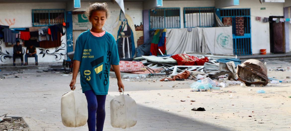 Jovem coleta água em Gaza.