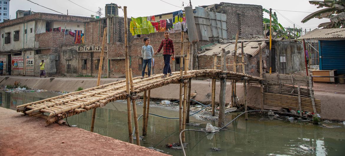 Um canal poluído atravessa uma favela nos arredores de Dhaka, capital de Bangladesh